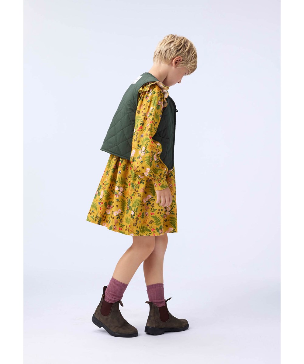 Constance - Foraging - Lange gele kinderjurk met lange mouwen met ruches en een print van bladeren, bloemen en noten.