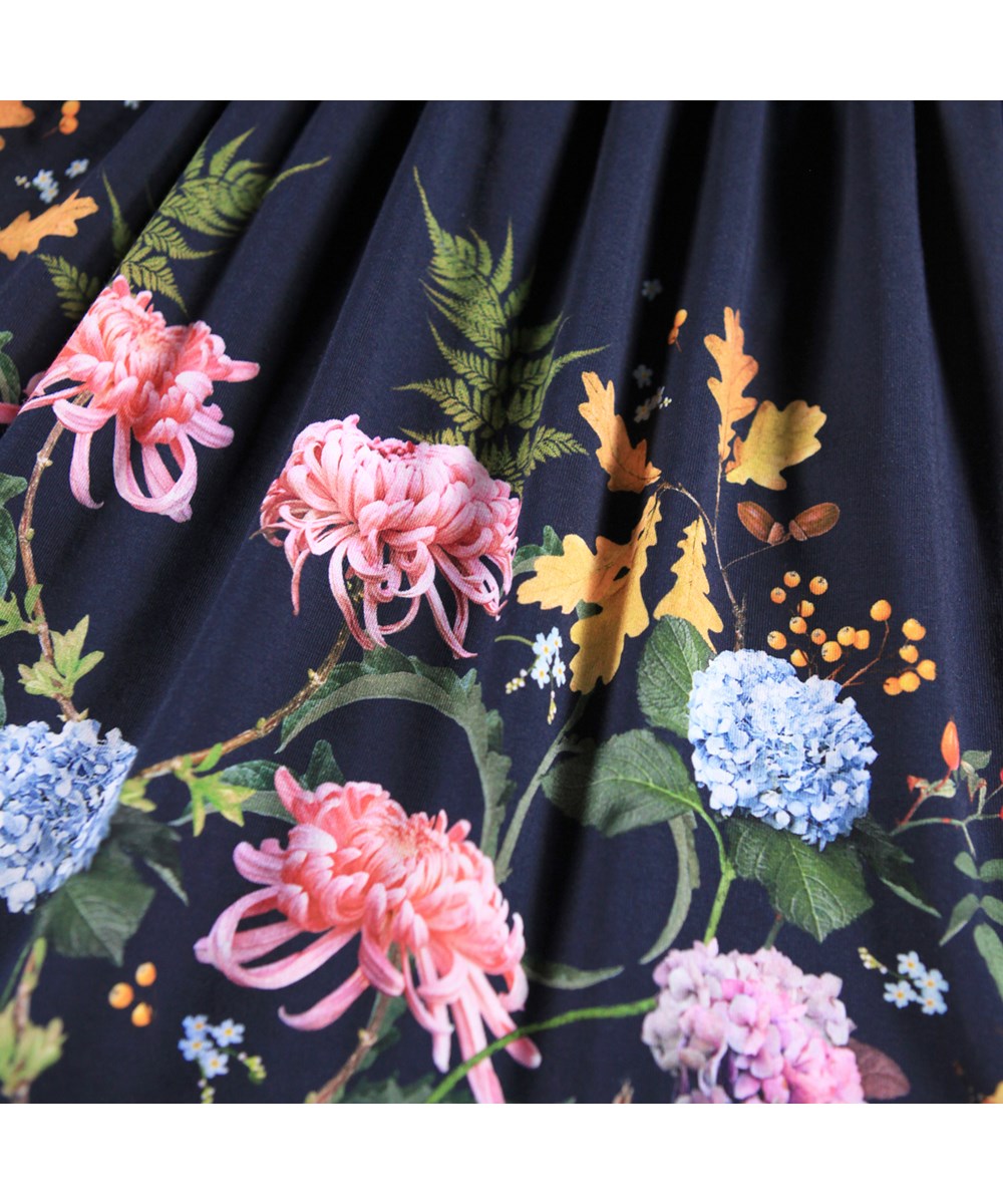 Credence - Nouveau Garden - Donkerblauwe kinderjurk gemaakt van biologisch katoenen jersey met lange mouwen en een print van bladeren en bloemen.