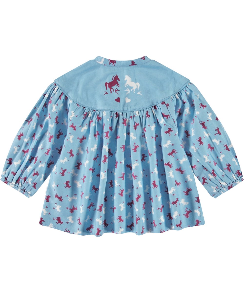 Rona - Giddy-Up - Lichtblauwe ruimvallende kindershirt van zacht katoen en viscose met een mandarijnkraag en plooien.