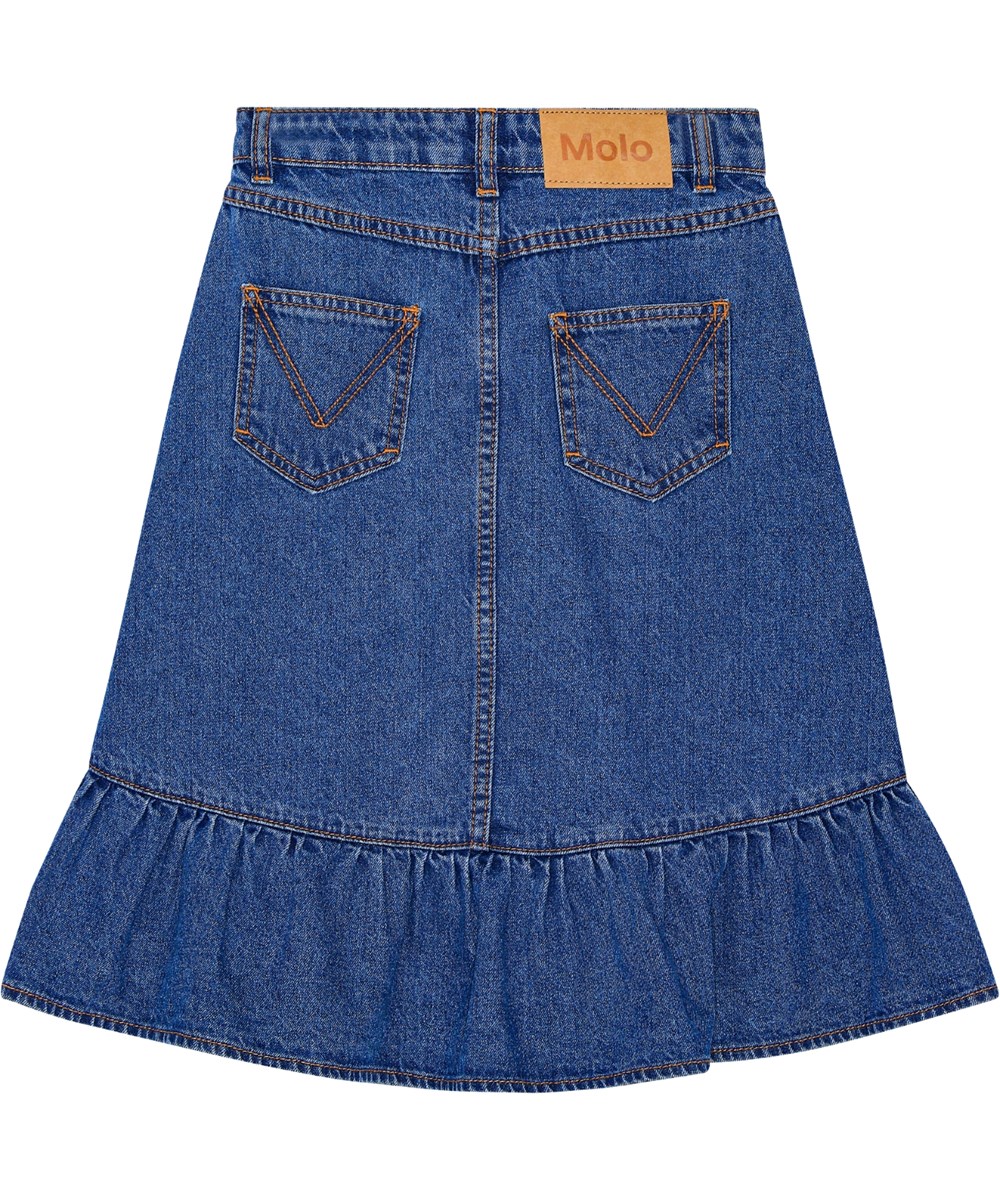 Belinda - Mid Blue Denim - Blauwe spijkerrok met ruches aan de rand, knielengte aan de voorkant en langer aan de achterkant.
