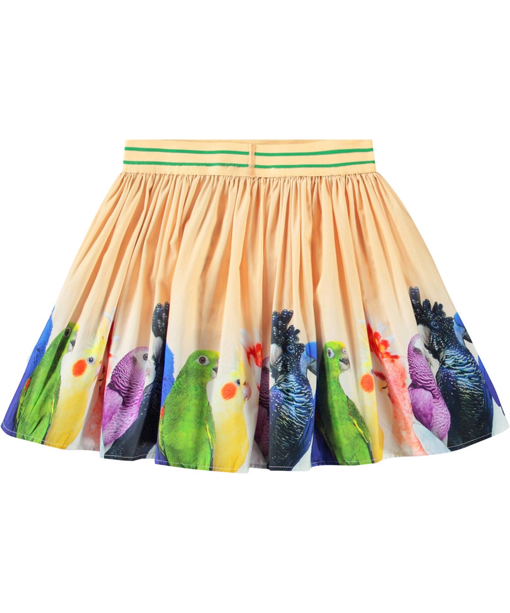 Brenda - Rainbow Parrots - Lichtoranje cirkelvormige kinderrok van biologisch katoen. De jurk heeft een print van kleine kleurrijke papegaaien.