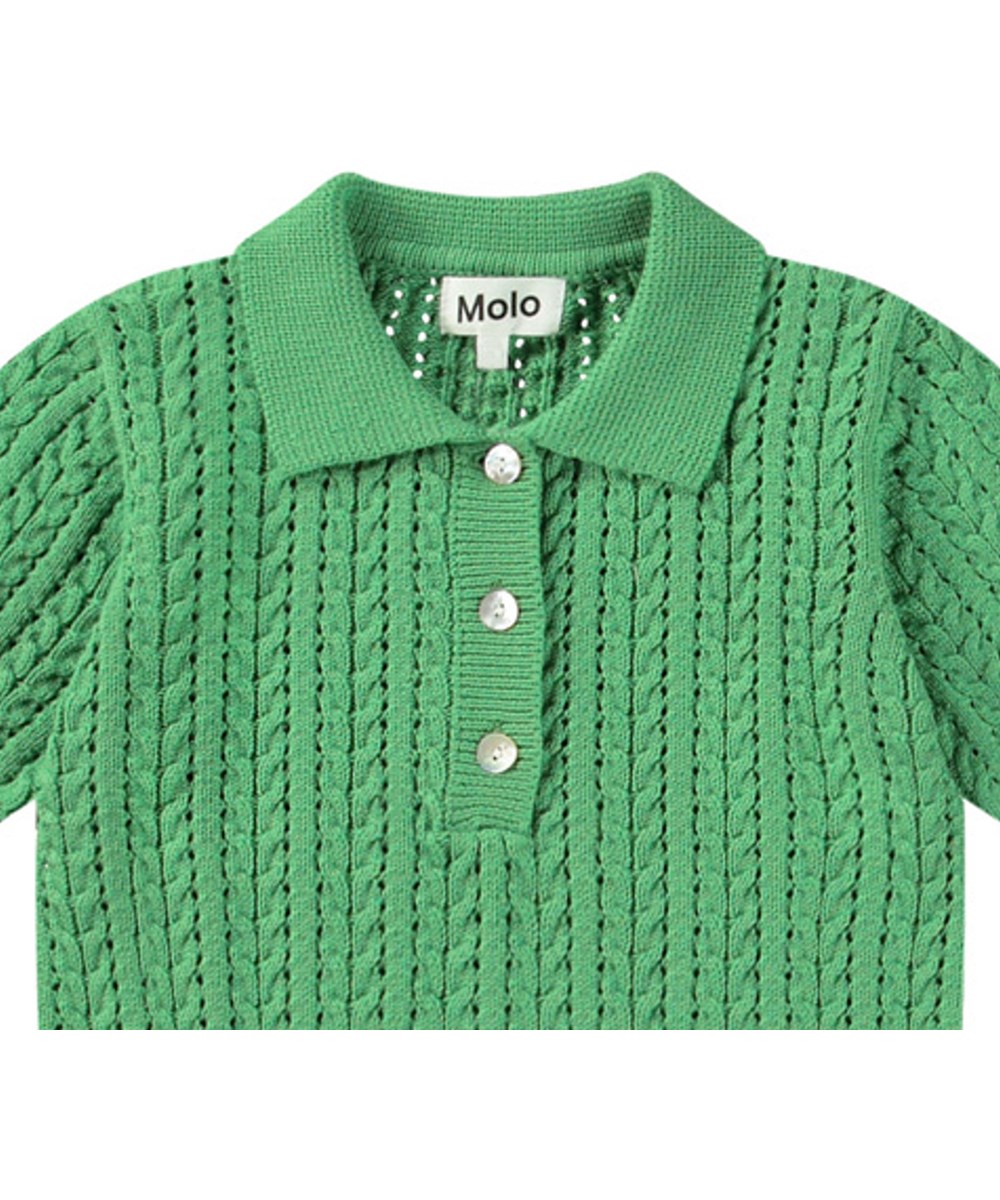 Gretel - Jungle Power - Gebreide groene kindertop van zacht biologisch katoen met parelmoeren knoopjes.