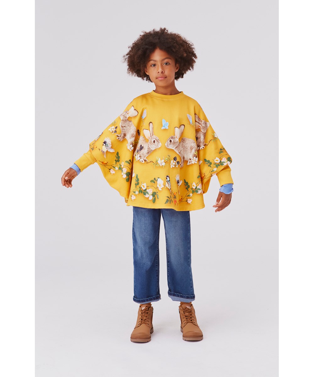 Marcella - In The Woods - Gele biologische poncho sweater met een konijn en vogelprint