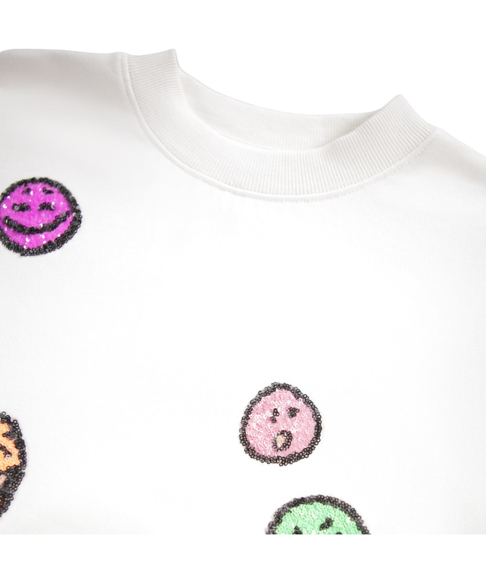Marge - Buttercream - Gebroken witte kindersweater gemaakt van biologisch katoen met geborduurde paillettengezichten.