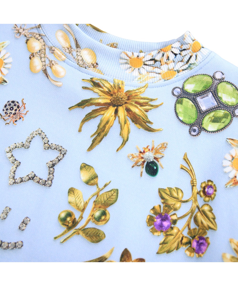 Marge - Royal Bling - Lichtblauwe sweater gemaakt van biologisch katoen met een print van prachtige sieraden.