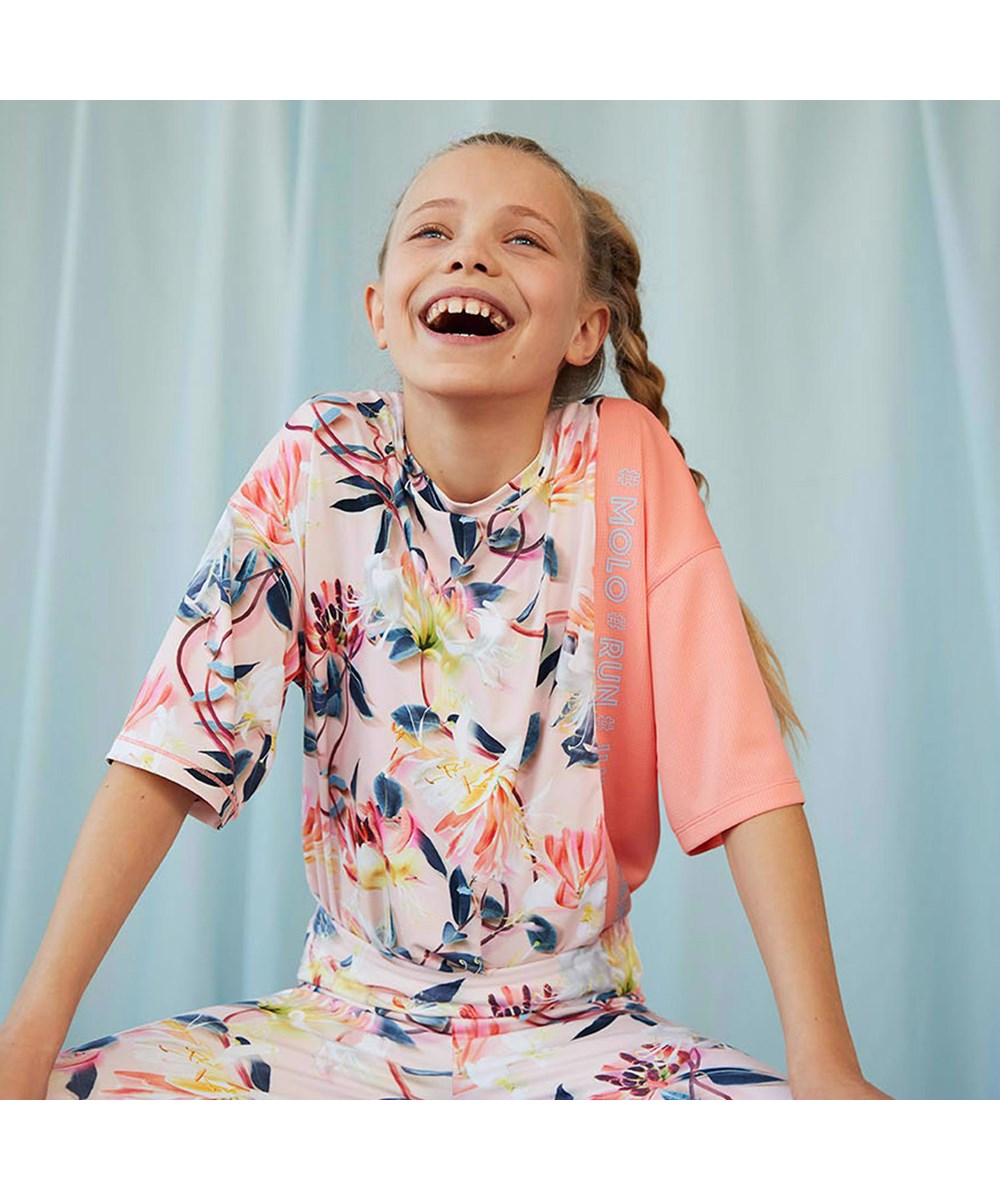 Odessa - Motion Flower - Ruimvallende lichtroze t-shirt met bloemenprint voor sporters