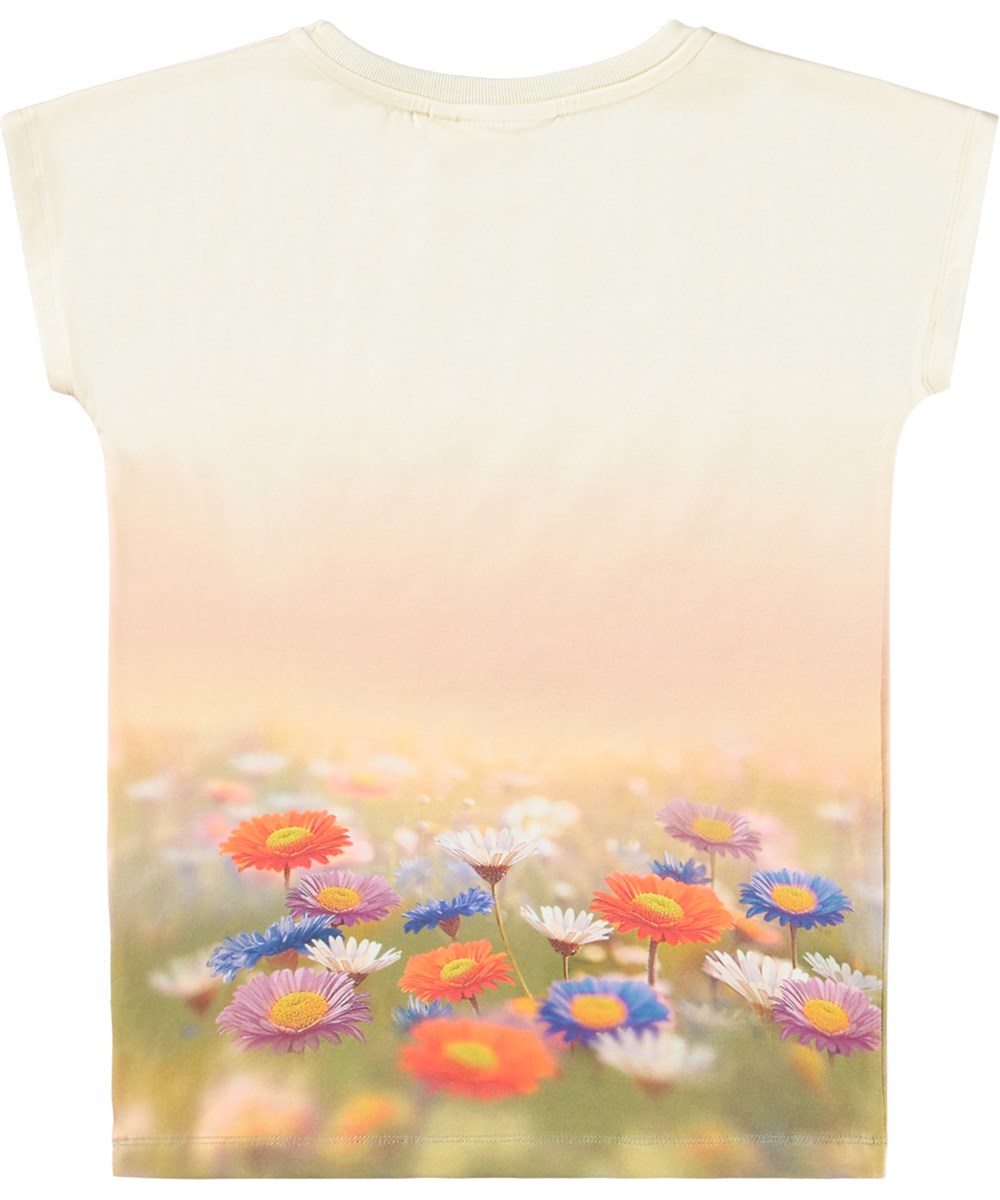 Ragnhilde - Bunny Rabbit - Lichtoranje kinder t-shirt gemaakt van biologisch katoen met op de voorkant een print van een konijn in een kleurrijk bloemenveld.