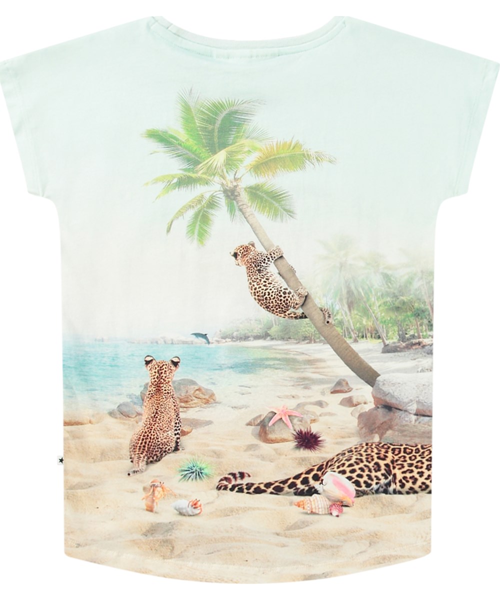 Ragnhilde - On The Beach - Elastische lichtblauwe kinder t-shirt van biologisch katoen met korte mouwen en ribboord rond de hals.