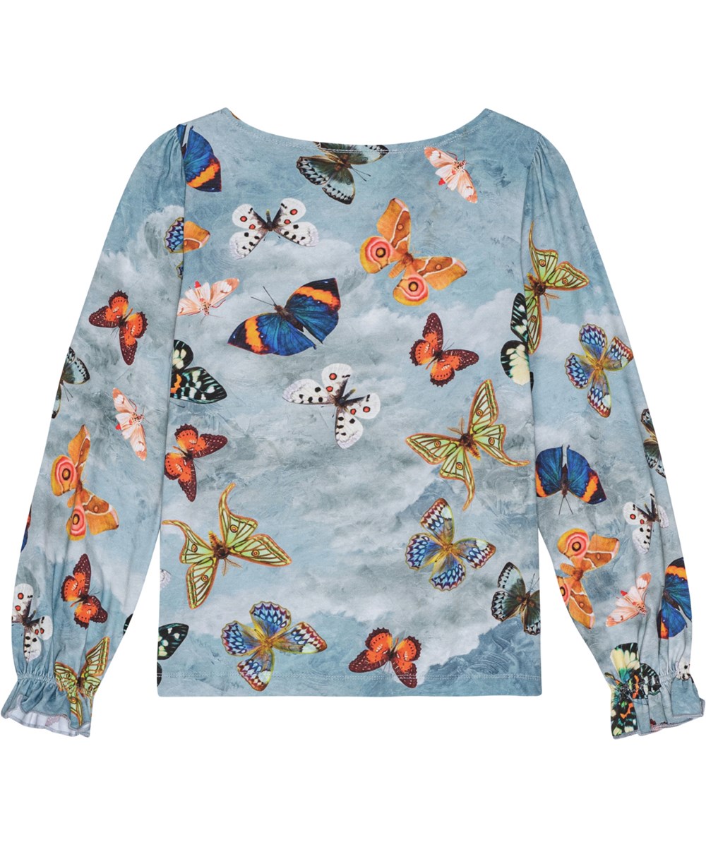 Raina - Les Papillons - Blauwe biologisch katoenen shirt met kleurrijke vlinderprint en geplooide mouwen.