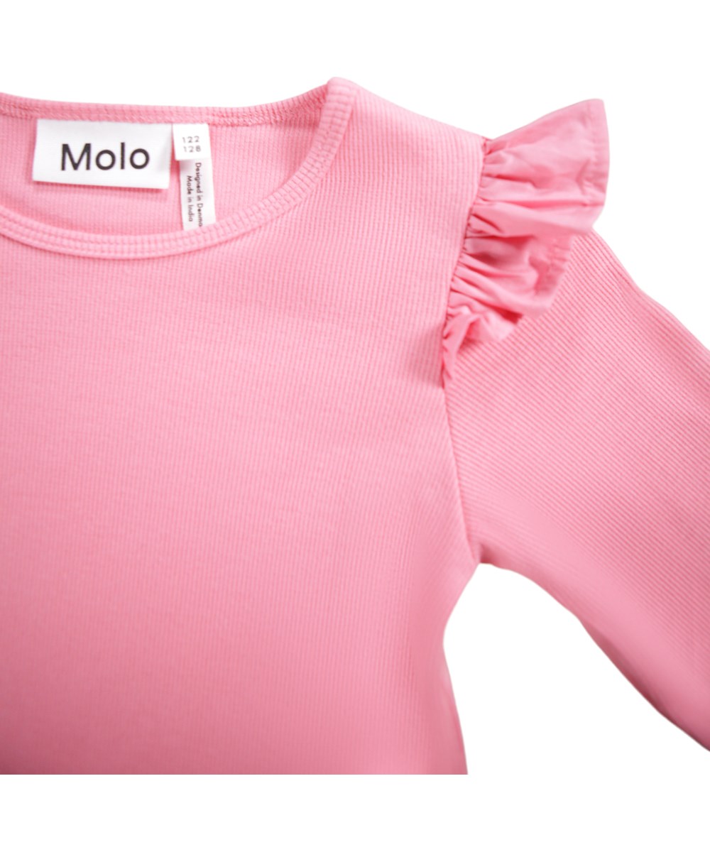 Rasmine - Confetti - Roze aansluitende longsleeve voor kinderen gemaakt van zacht biologisch katoenen ribstof met een ronde hals en ruches op de schouder.