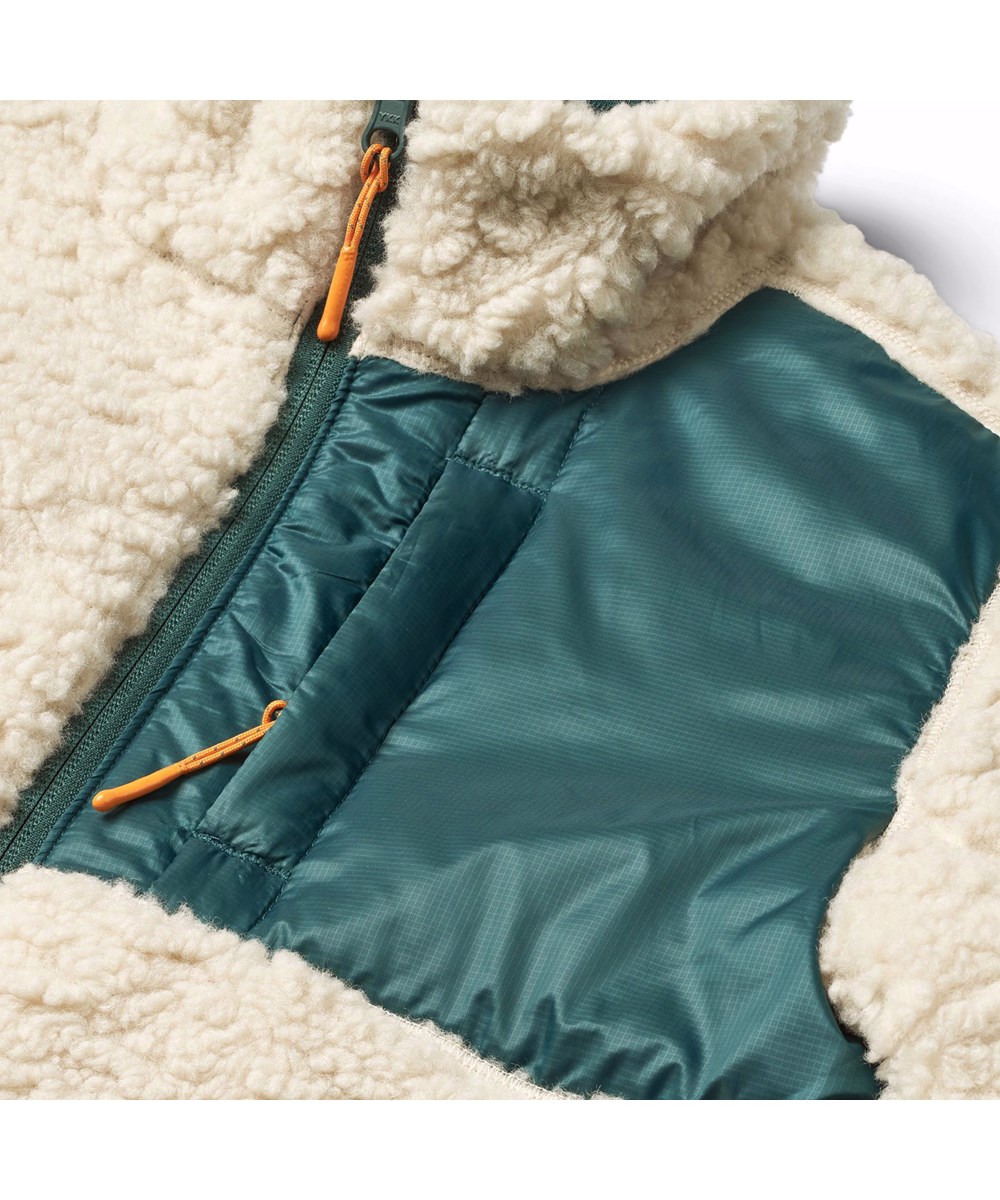 Ugo - Ponderosa Pine - Wendbare Fleecejacke für Kinder in dunkelgrün und off-weiß.