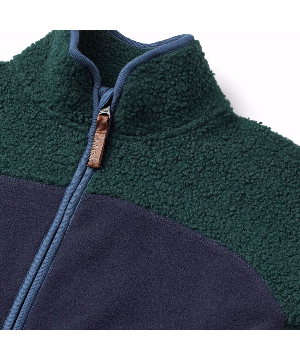 Ulani - Dark Night - Dunkelblaue und grüne Fleecejacke für Kinder mit blauen Details.