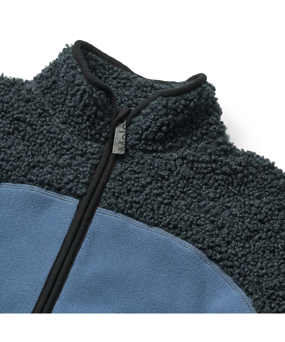 Ulani - Night Navy - Blaue Fleecejacke für Kinder aus recyceltem Polyester mit passenden gerippten Abschlüssen und einer vorderen Tasche.