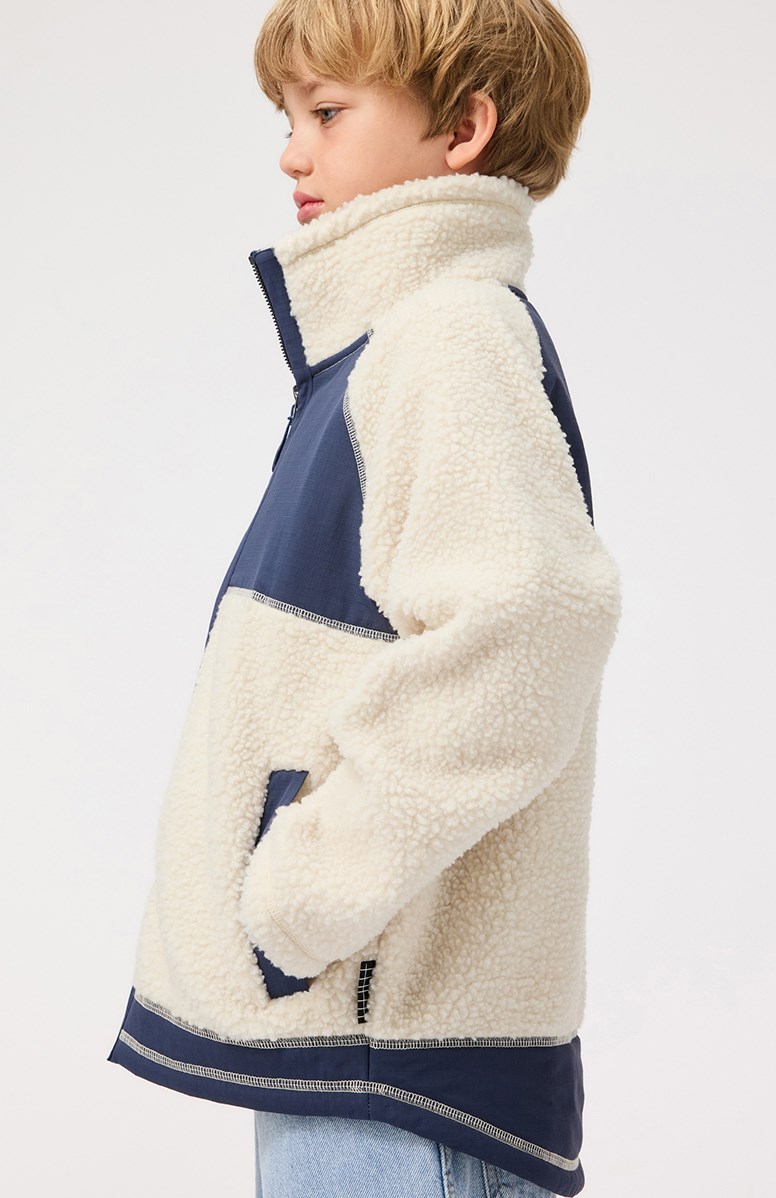 Usher - Summer Sand - Off-weiße Fleecejacke für Kinder aus recyceltem Polyester mit vorderen Taschen und blauen strapazierfähigen Details.