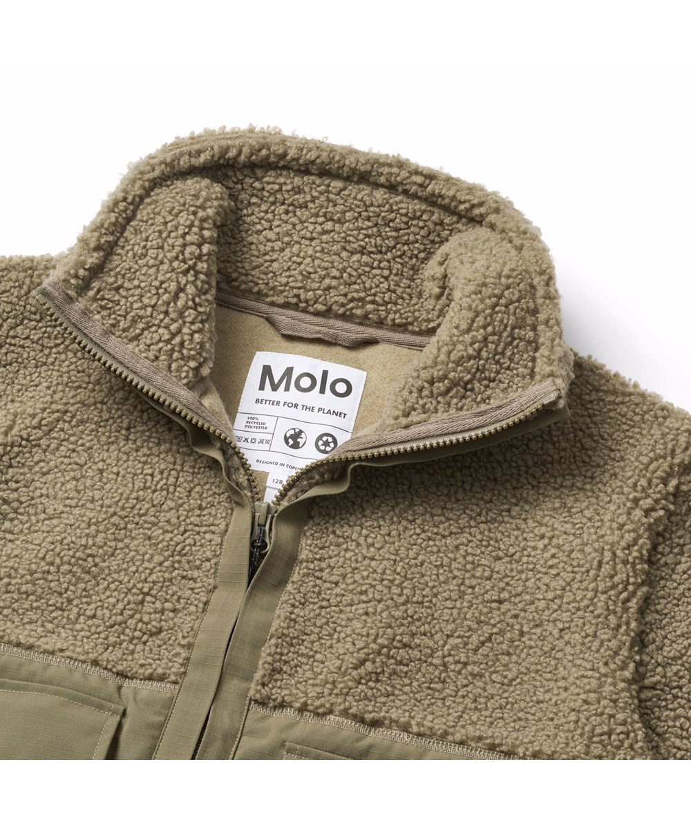 Utha - Bark Green - Dunkelgrüne Fleecejacke für Kinder aus recyceltem Polyester mit Details an den Ärmeln, am Rücken und an den äußeren Vordertaschen, die aus wind- und wasserabweisendem strapazierfähigem Nylon gefertigt sind.