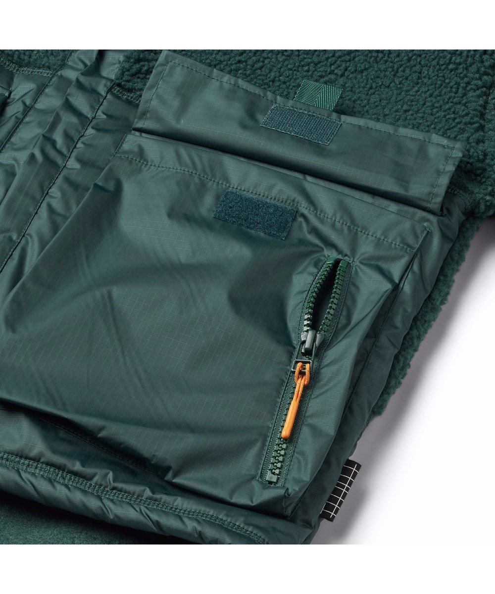 Utha - Ponderosa Pine - Dunkelgrüne Fleecejacke für Kinder mit großen externen Vordertaschen.