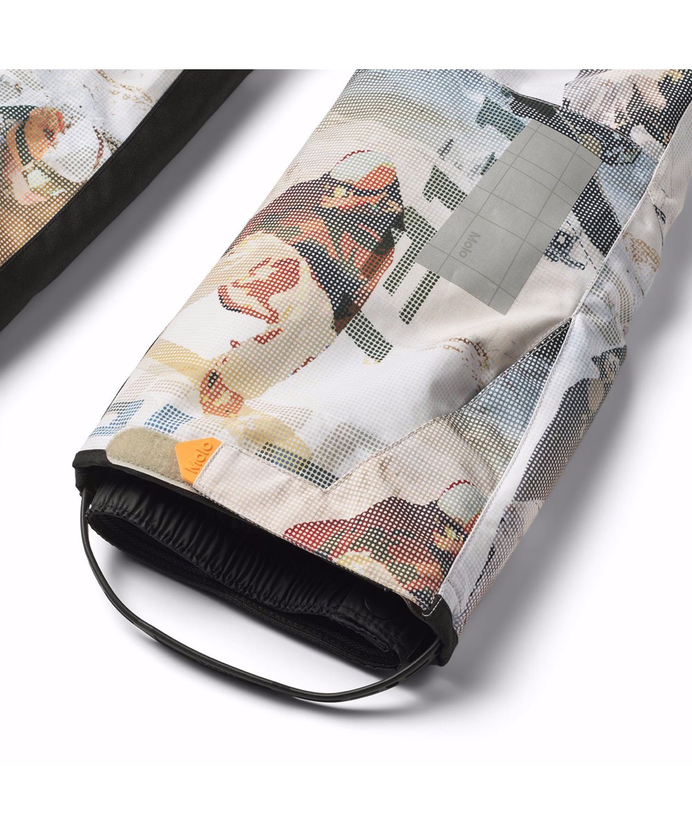 Jump Pro - Spin 1260 - Wind- und wasserdichte Kinderhosen aus recyceltem Polyester mit einem Pixel-Druck eines coolen Snowboarders in den Alpen.