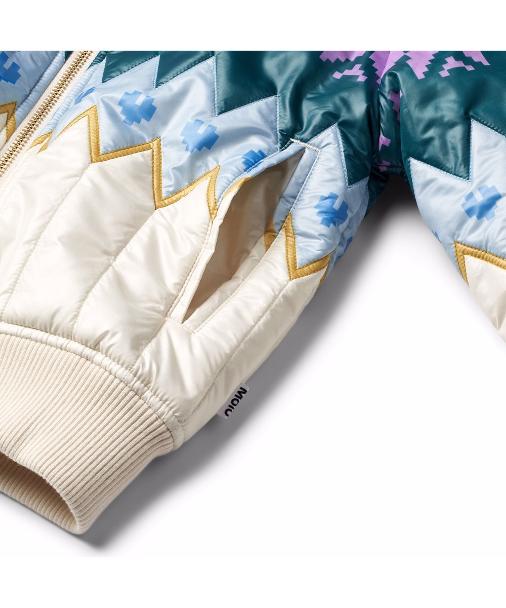 Henna - Grande Nordic - Off-White gesteppte Jacke für Kinder mit norwegisch inspiriertem Muster in mehreren Farben.