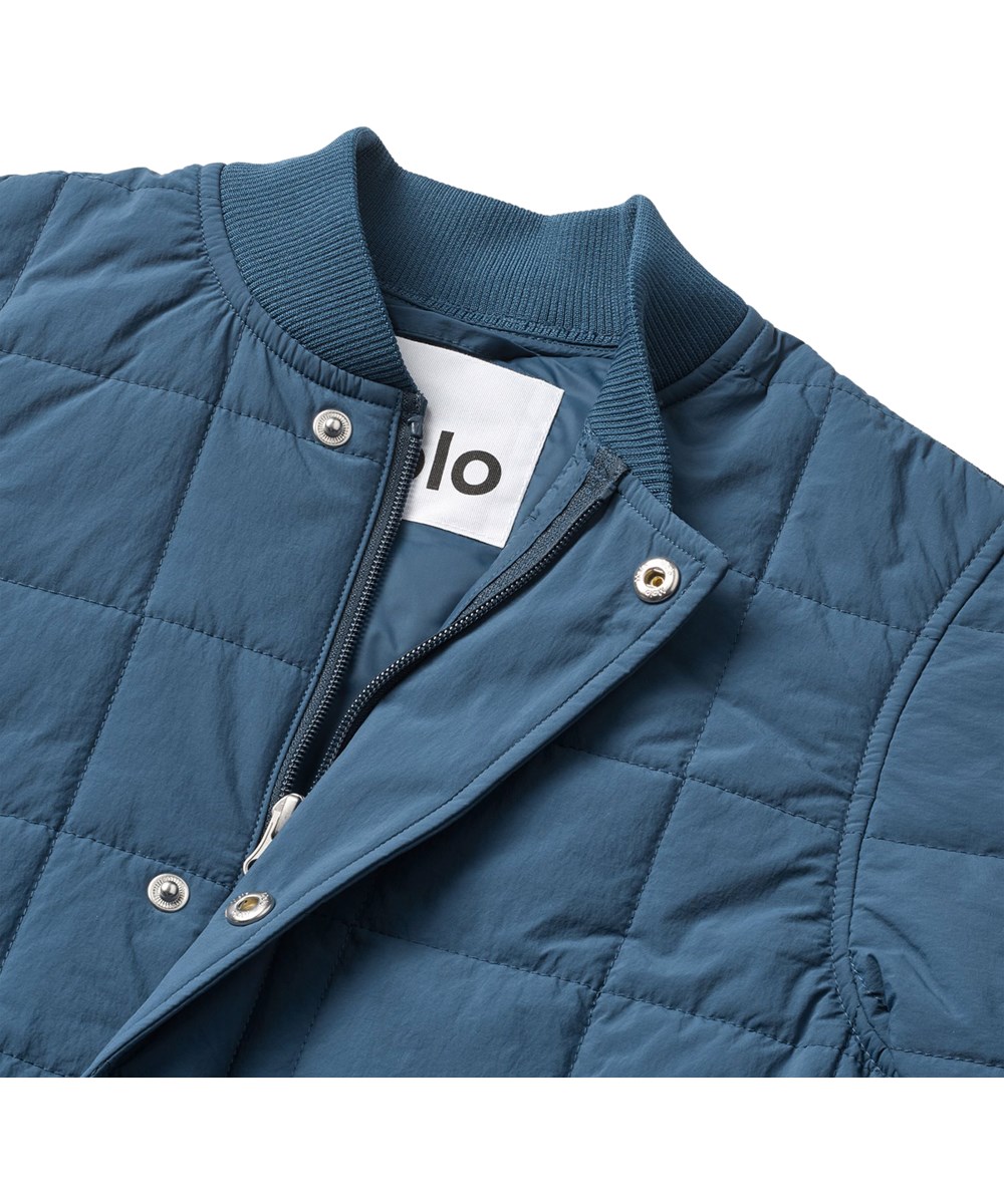 Harold - Oceanica - Blaue wind- und wasserabweisende gesteppte Baumwolljacke für Kinder mit weichem Rippstrick am Hals und an den Ärmeln.