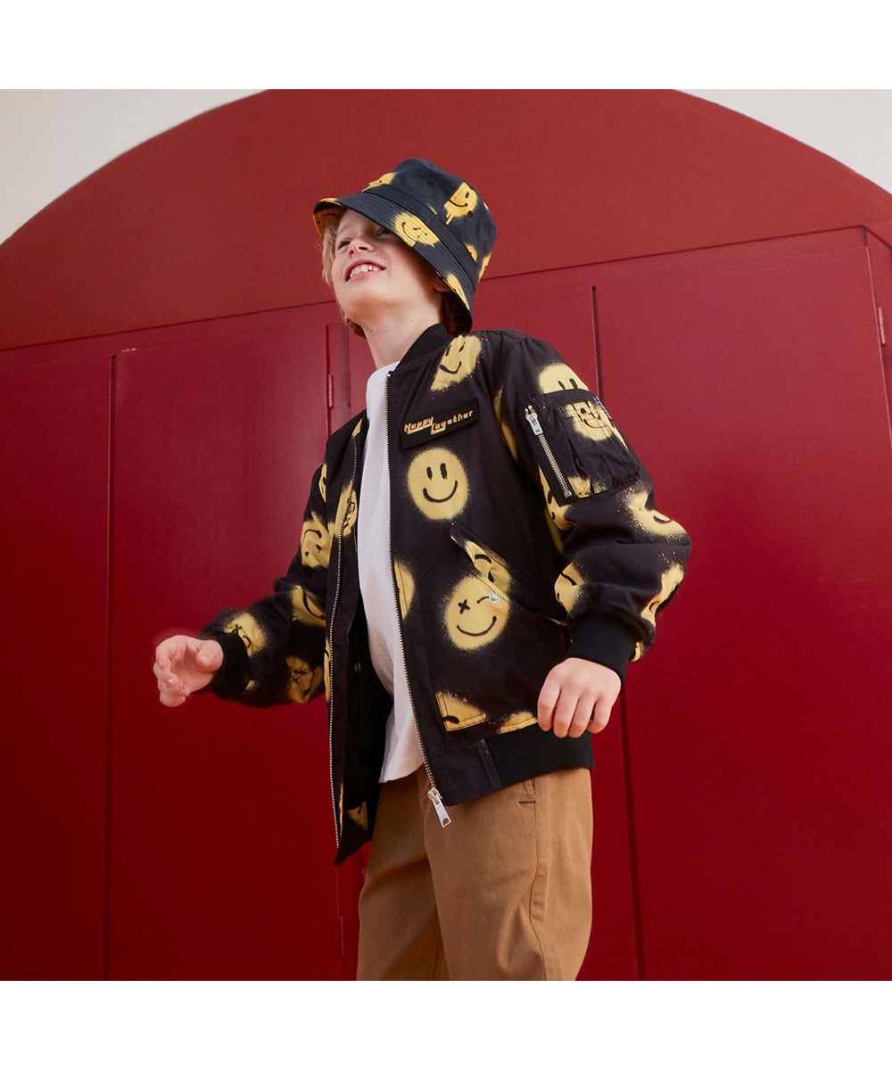 Heath - Happy! - Schwarze Bomberjacke mit gelben Smileys.