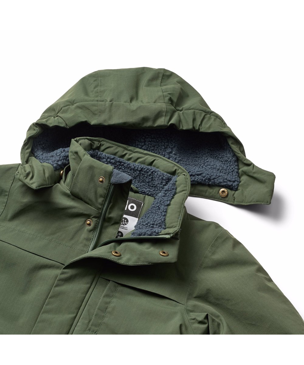 Heiko - Dark Forest - Wind- und wasserabweisende dunkelgrüne Jacke für Kinder aus recyceltem Nylon mit praktischem Reißverschluss, hohem Kragen und abnehmbarer gefütterter Kapuze.