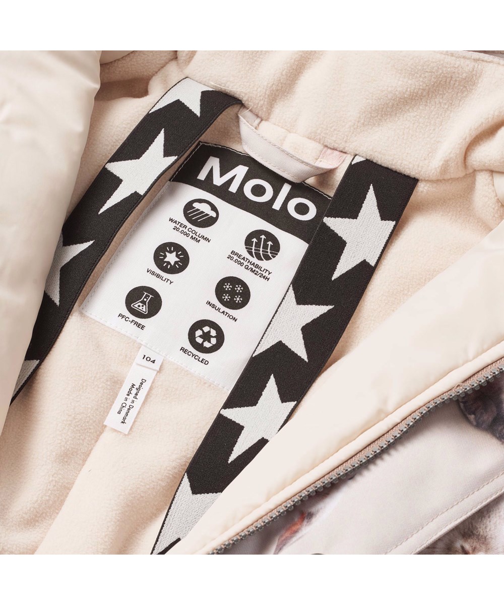 Polaris Fur - Winter Rabbits - Kinder-Schneeanzug aus recyceltem Polyester mit einem Druck von niedlichen Hasen zwischen Schneeglöckchen auf einem grauen Hintergrund.