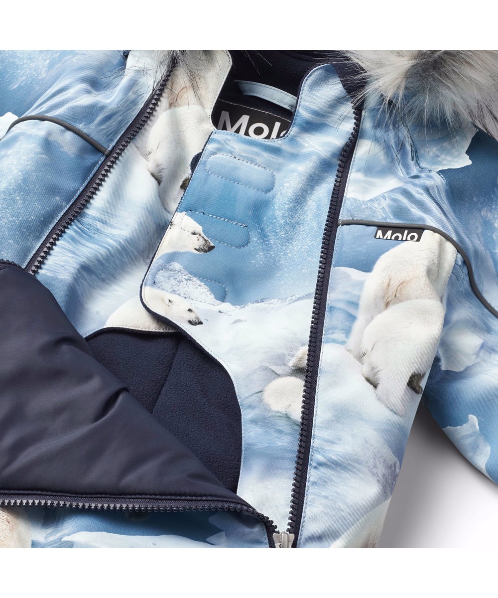 Pyxis Fur - Polar Bear Joy - Kinder-Schneeanzug aus recyceltem Polyester mit einem Druck von verspielten Eisbären auf Eisschollen in Blautönen.