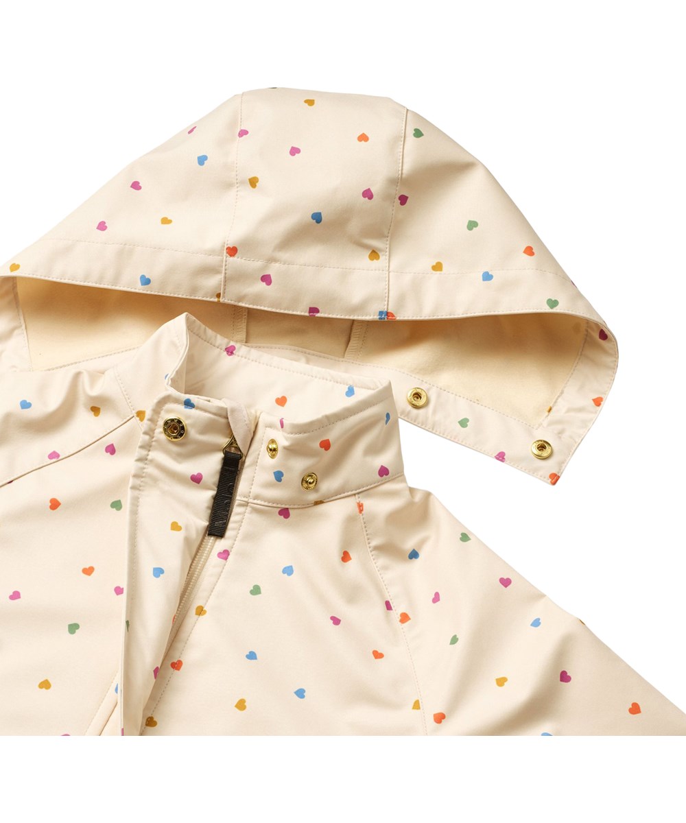 Hillary - Confetti_Rainbow - Wind and water-repellent jacket for children made from recycled polyester with fleece lining and a heart print in rainbow colours.