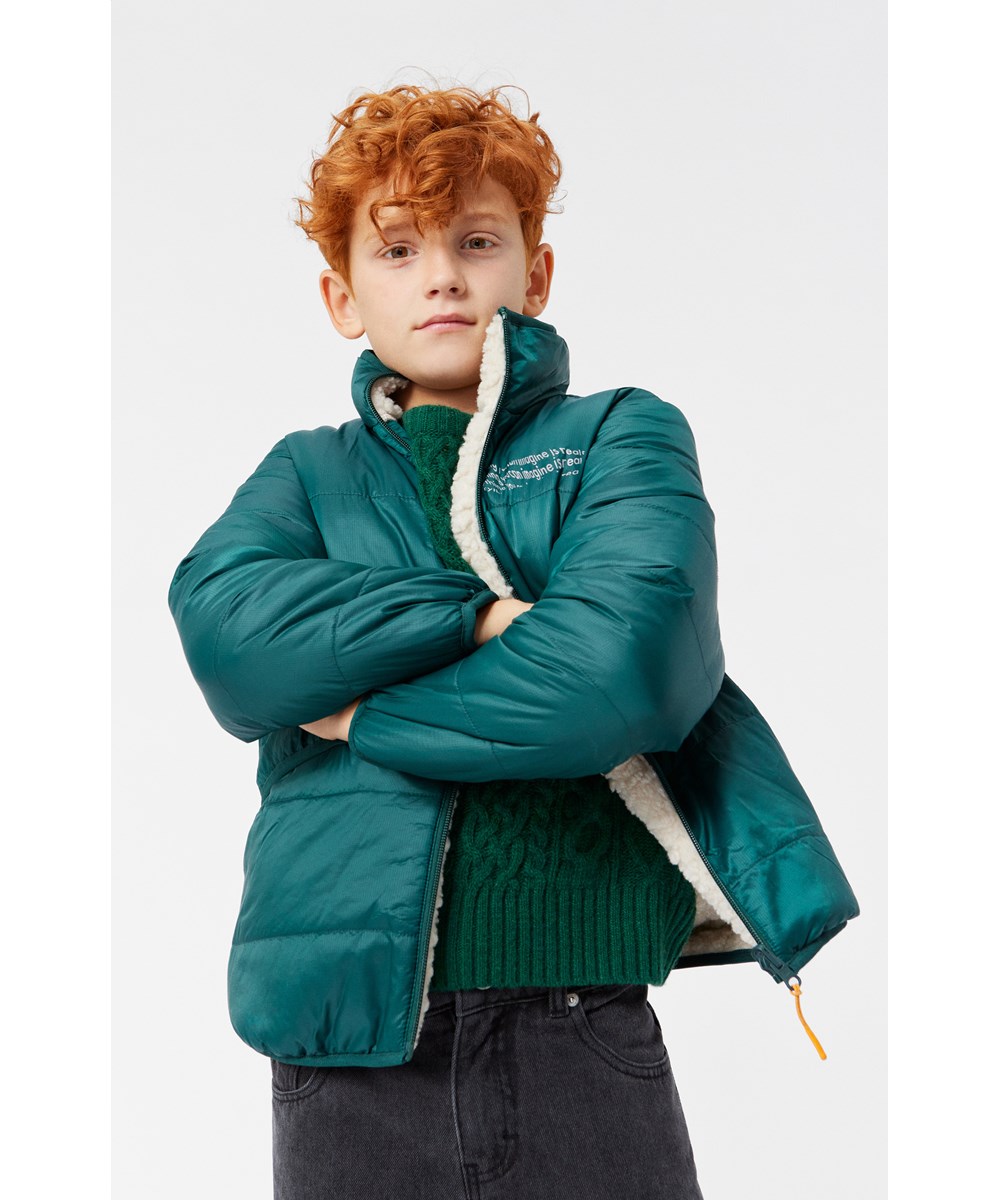 Ugo - Ponderosa Pine - Reversible fleece jacket for children in dark green and off-white.