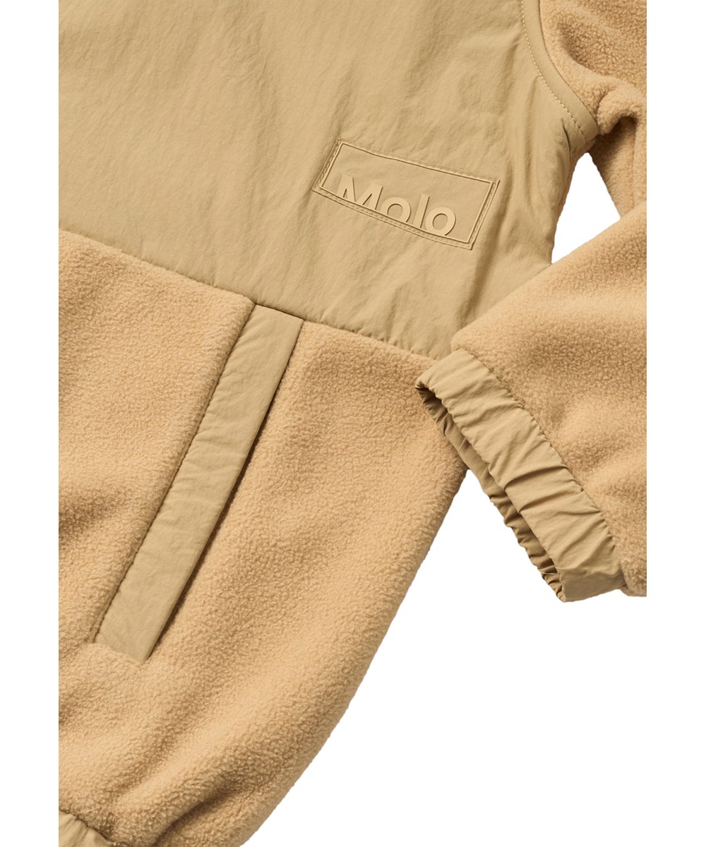 Utta - Desert - Sand-coloured fleece jacket for children made from recycled polyester with a racing car on the back.