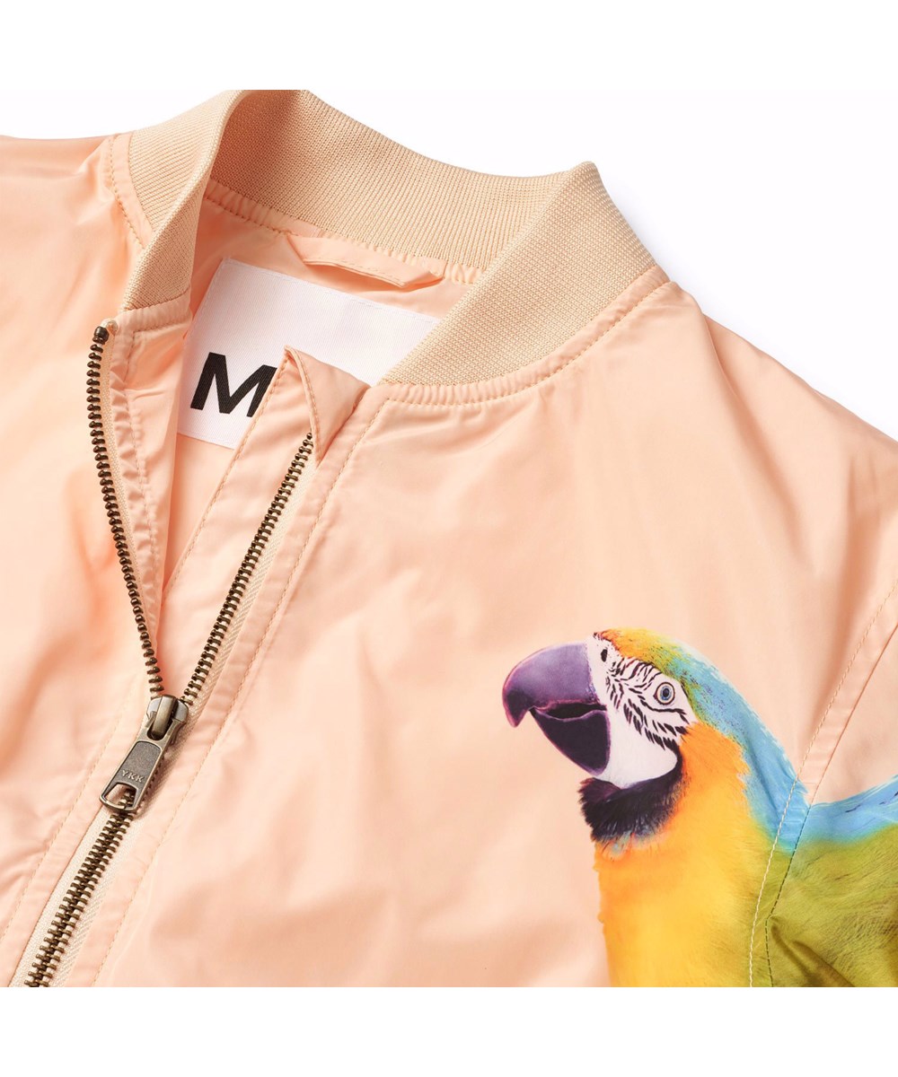 Haliva - Fantasy Parrots - Coral-coloured, water-repellent (PFC-free: PFOS and PFOA) bomber jacket for children in recycled polyester with a colourful print of parrots on the sleeves.