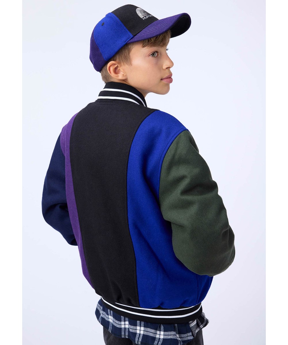 Hani - More Colours - Baseball jacket in black, blue, green, and purple colors made of a sturdy wool blend.