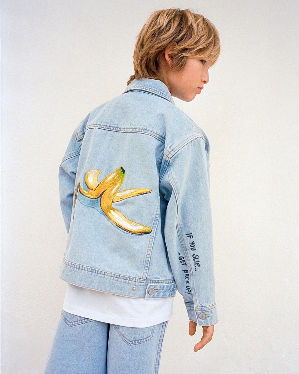 Honore - Sun-Bleach Blue - Light blue denim jacket for children in cotton with a banana peel embroidery on the back and the text on the sleeve "If you slip.... Get back up".