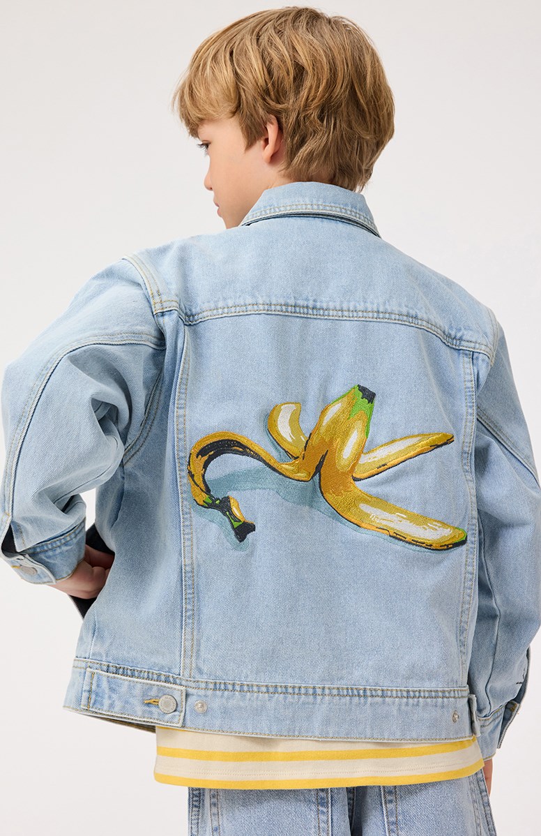 Honore - Sun-Bleach Blue - Light blue denim jacket for children in cotton with a banana peel embroidery on the back and the text on the sleeve "If you slip.... Get back up".