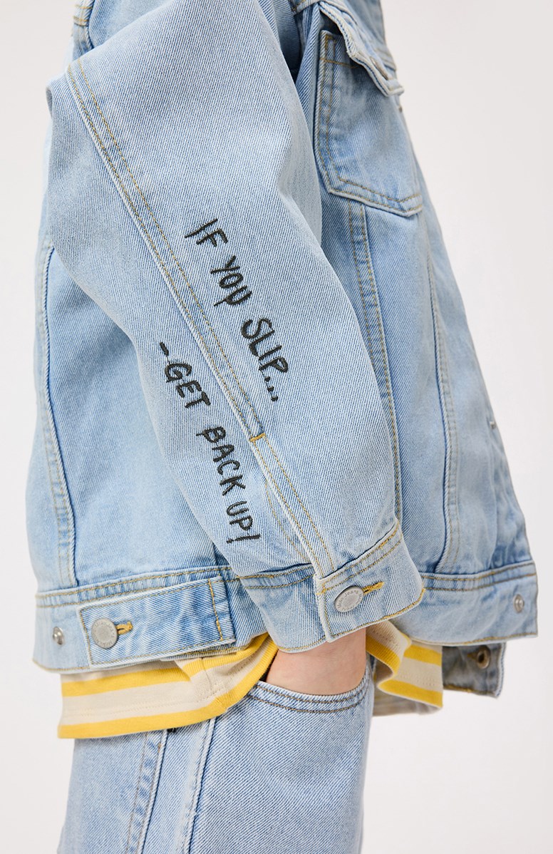 Honore - Sun-Bleach Blue - Light blue denim jacket for children in cotton with a banana peel embroidery on the back and the text on the sleeve "If you slip.... Get back up".