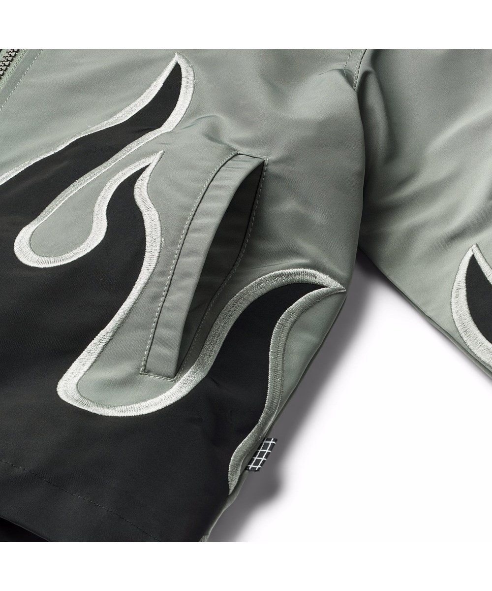 Hotson - Heated - Grey jacket for children with black flames made of shiny polyester.