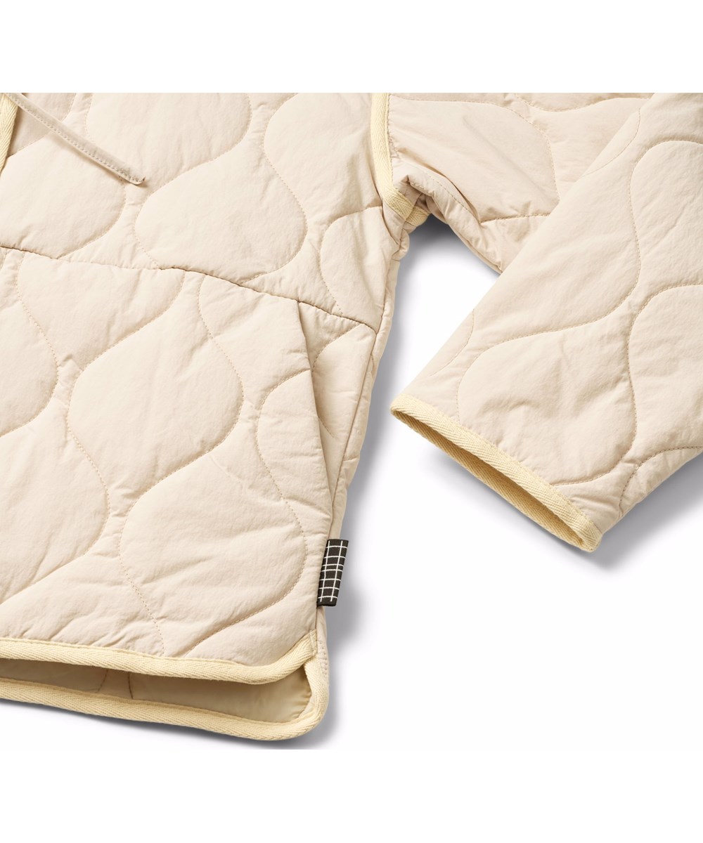 Hailey - Soft Powder - Beige wind and water-repellent padded jacket for children made of soft cotton with wavy quilted pattern.