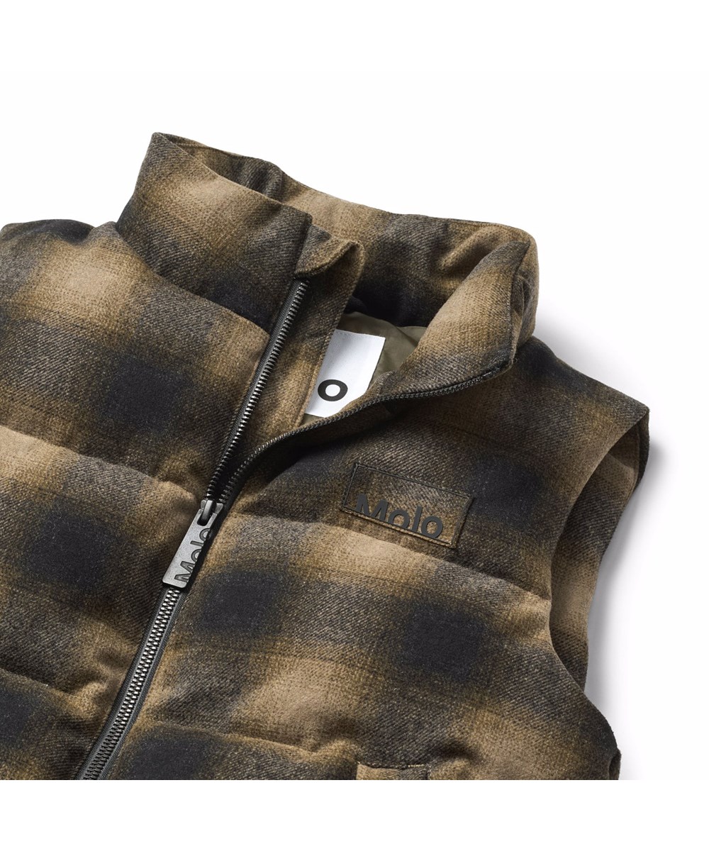 Heike - Bark Check - Checkered brown puffer vest for children made of recycled polyester and wool blend with internal adjustable elastic bands that keep the wind out.