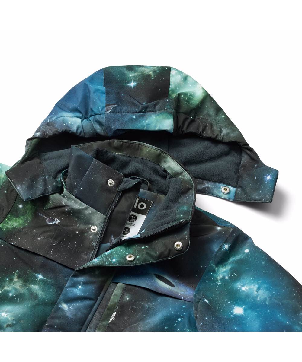 Heiko - Far Out - Wind- and water-repellent jacket for children with space print in recycled nylon. The jacket has a practical zip closure, high collar, and detachable lined hood.