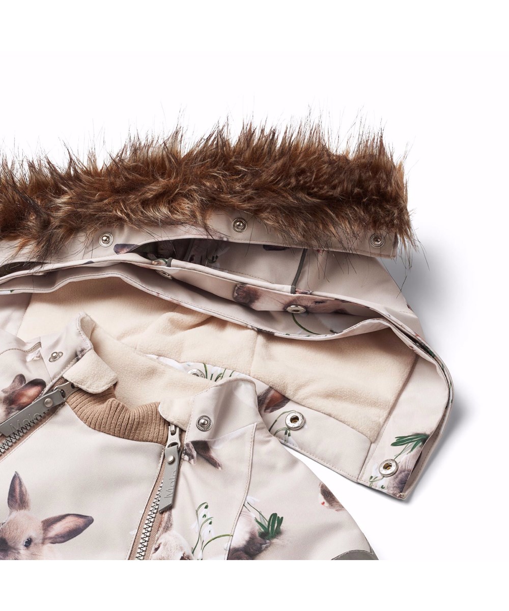 Hopla Fur - Winter Rabbits - Wind- and waterproof winter jacket for children in recycled polyester with a print of cute rabbits among snowdrops on a grey background.