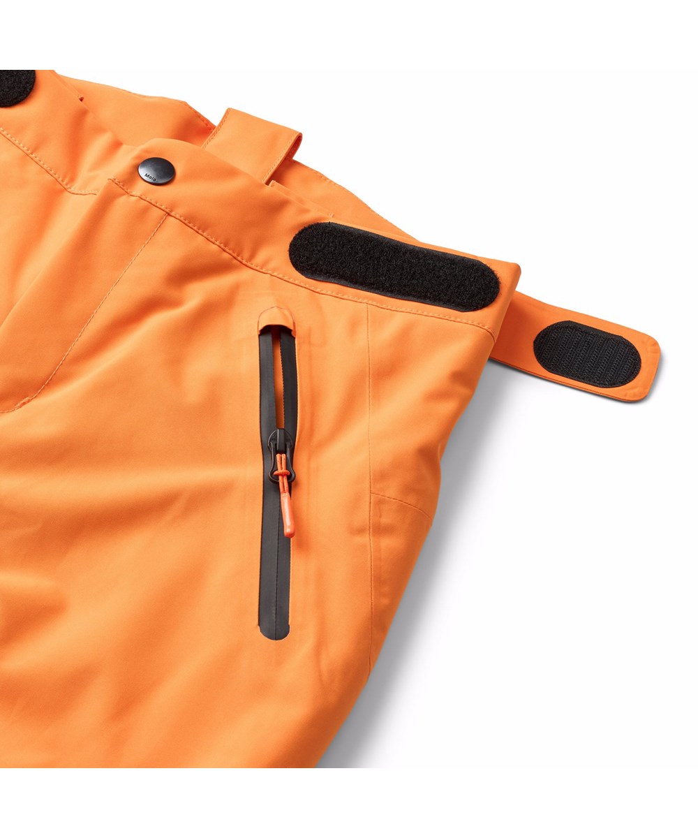 Jump Pro - Lava Orange - Orange wind and waterproof ski pants for children made of recycled polyester and padded with 3M™ Thinsulate™.
