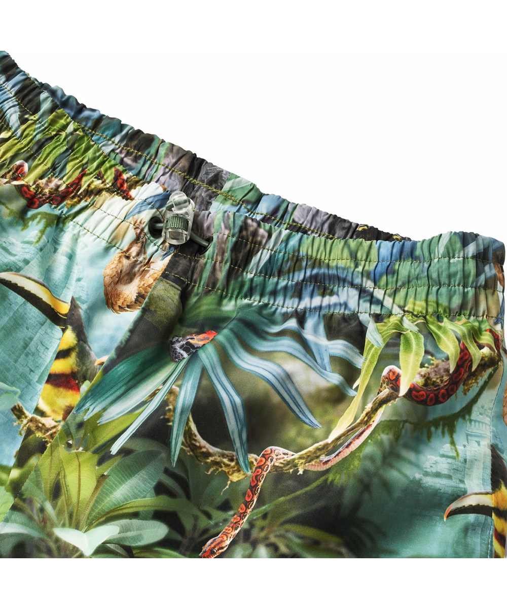 Waits - Jungle Life - Green wind and waterproof rain trousers for children in durable and recycled polyester.