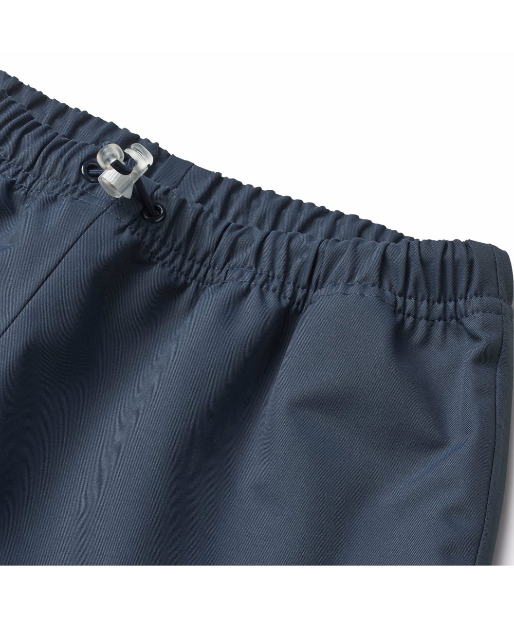 Waits - Mood Blue - Dark blue wind and waterproof rain trousers for children in durable and recycled polyester.