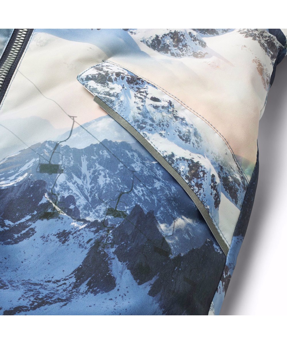 Hyde - Mountain High - Warm snowsuit for babies and toddlers in recycled polyester with a winter landscape print in shades of blue.