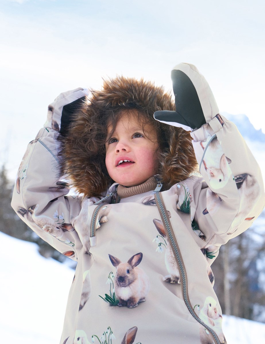Pyxis Fur - Winter Rabbits - Children's snowsuit in recycled polyester with a print of cute rabbits among snowdrops on a grey background.