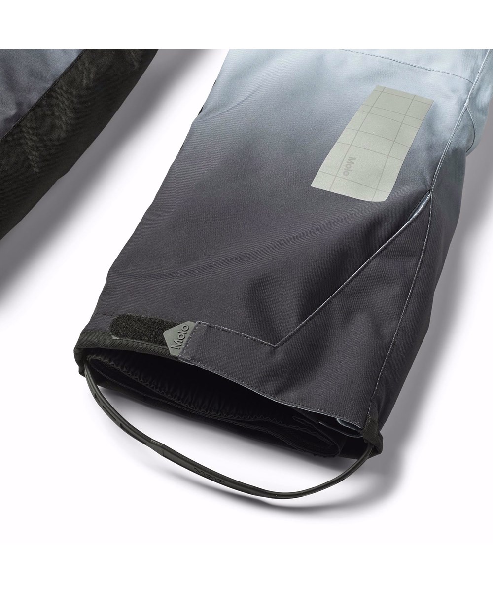 Jump Pro - High In Sky - Vind- og vandtætte overtrækker til en kold vinter i genanvendt polyester, med et print af snedækket alper, solens skær og en klar blå himmel. Bukserne er foret med 3M™ Thinsulate™