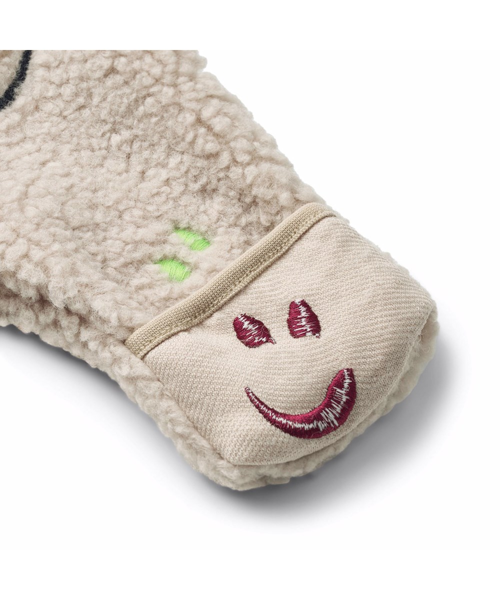 Umeko - Teddy Emotions - Beige fleecedragt til de mindste i genanvendt polyester med boderet smilende ansigter i forskellige farver og blødt bomulds foer.