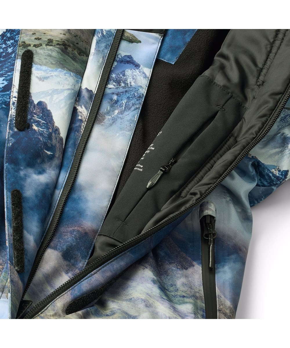 Hux - Snowy Mountains - Vind- og vandtæt flyverdragt med et flot landskabsprint, der viser snedækkede bjergtoppe i klare farver fremstillet i genanvendt polyester og vatteret med 3M™ Thinsulate™.