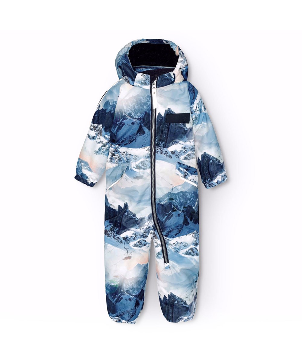 Hyde - Mountain High - Flyverdragt til en kold vinter i genanvendt polyester,  i et vinterlandskabsprint i blå nuancer. Flyverdragten har elastik i lænden, ved ærme- og ben afslutning, så sne, regn og vind holdes ude, samt holder på luffer og støvler