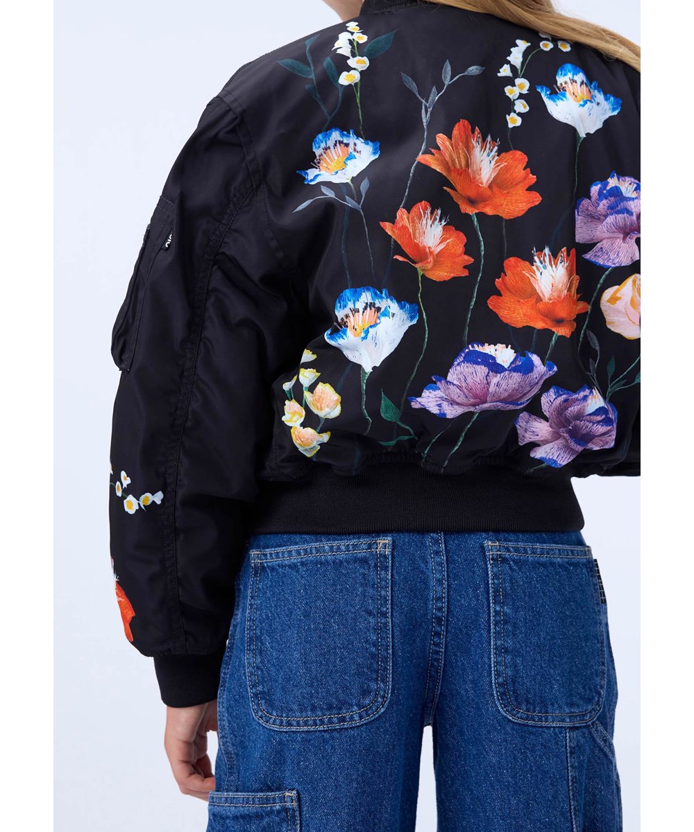 Hedia - Paper Flora - Sort bomberjakke til børn med et farverigt blomsterprint fremstillet i genanvendt polyester.